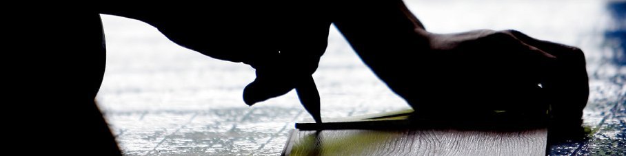 back-lit image of a person making a marking on a flooring plank