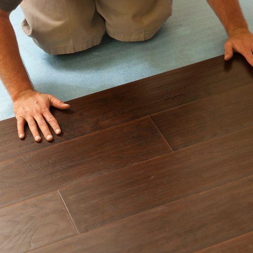 person installing wood flooring - Sullivan's Floor Covering INC